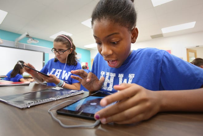 Students in the IGNITE Academy at Janie Howard Wilson Elementary work on a class project as Disney Imagineers creating a theme park ride based on a system of the human body using their iPad minis in 2013.