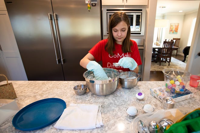 Evelyn Pagoria, 12, creates her Penguin bath bomb. The Penguin bath bomb is vanilla and peppermint scented, but her favorite is her Snowman bath bomb which is vanilla scented.