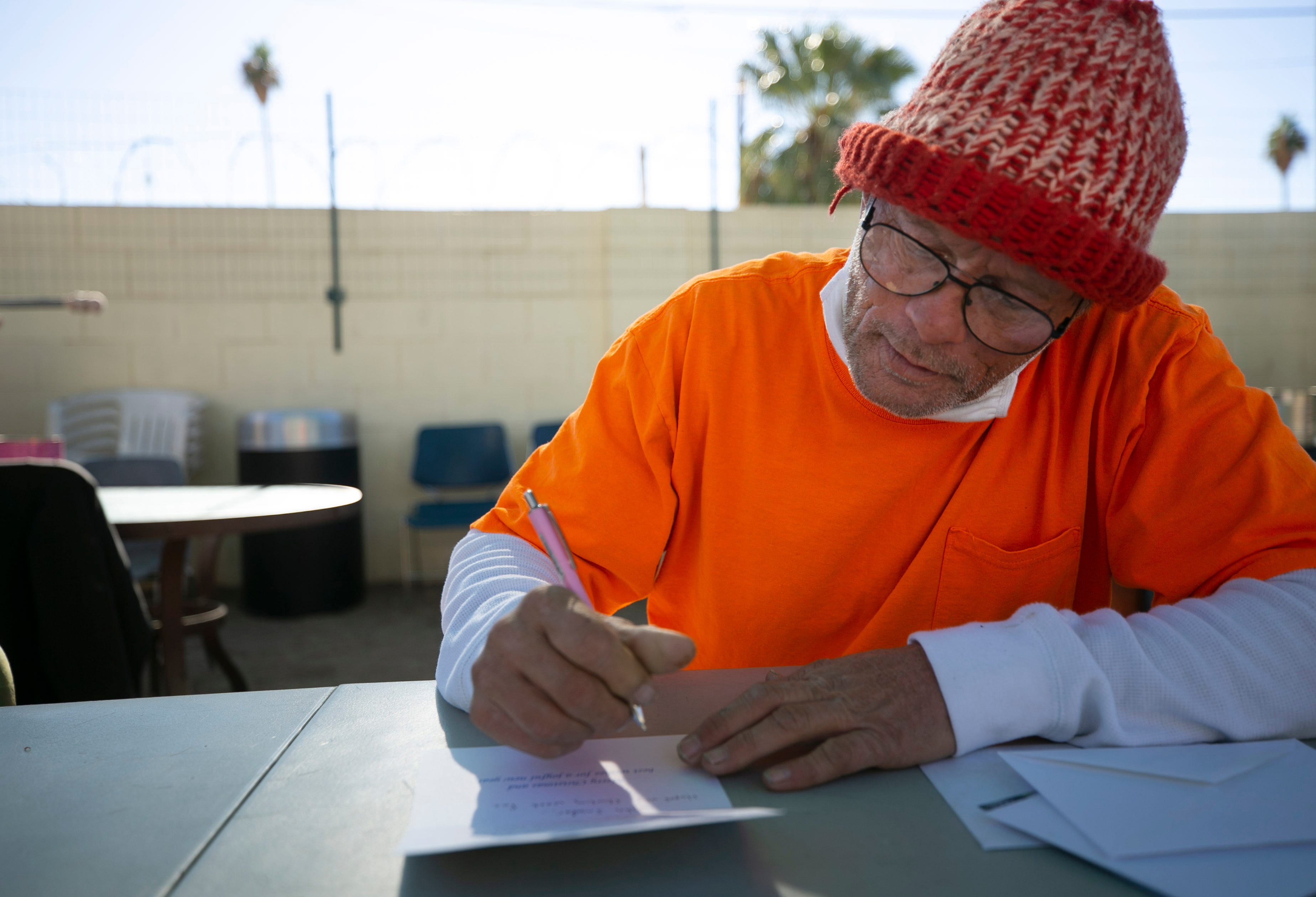John Snyder, 59, writes holiday cards at the Justa Center in Phoenix on Dec. 9, 2020.