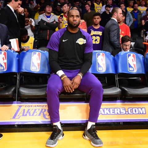 LeBron James sits on the bench before the start of