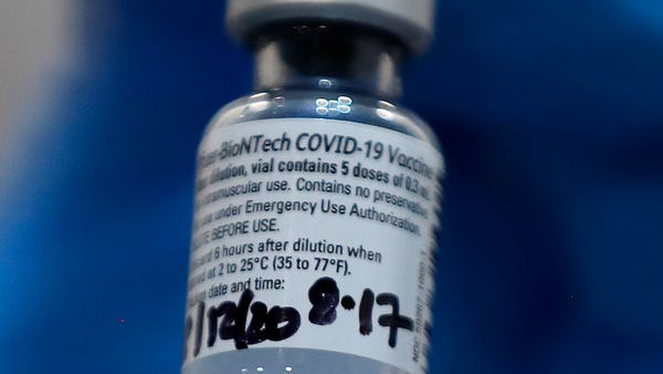 A nurse holds a phial of the Pfizer-BioNTech COVID