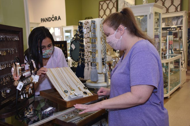 Jenna Picou (left) shows her customer Emma Gaudet the jewelry selection offered at Outside and In gift shop in Houma.