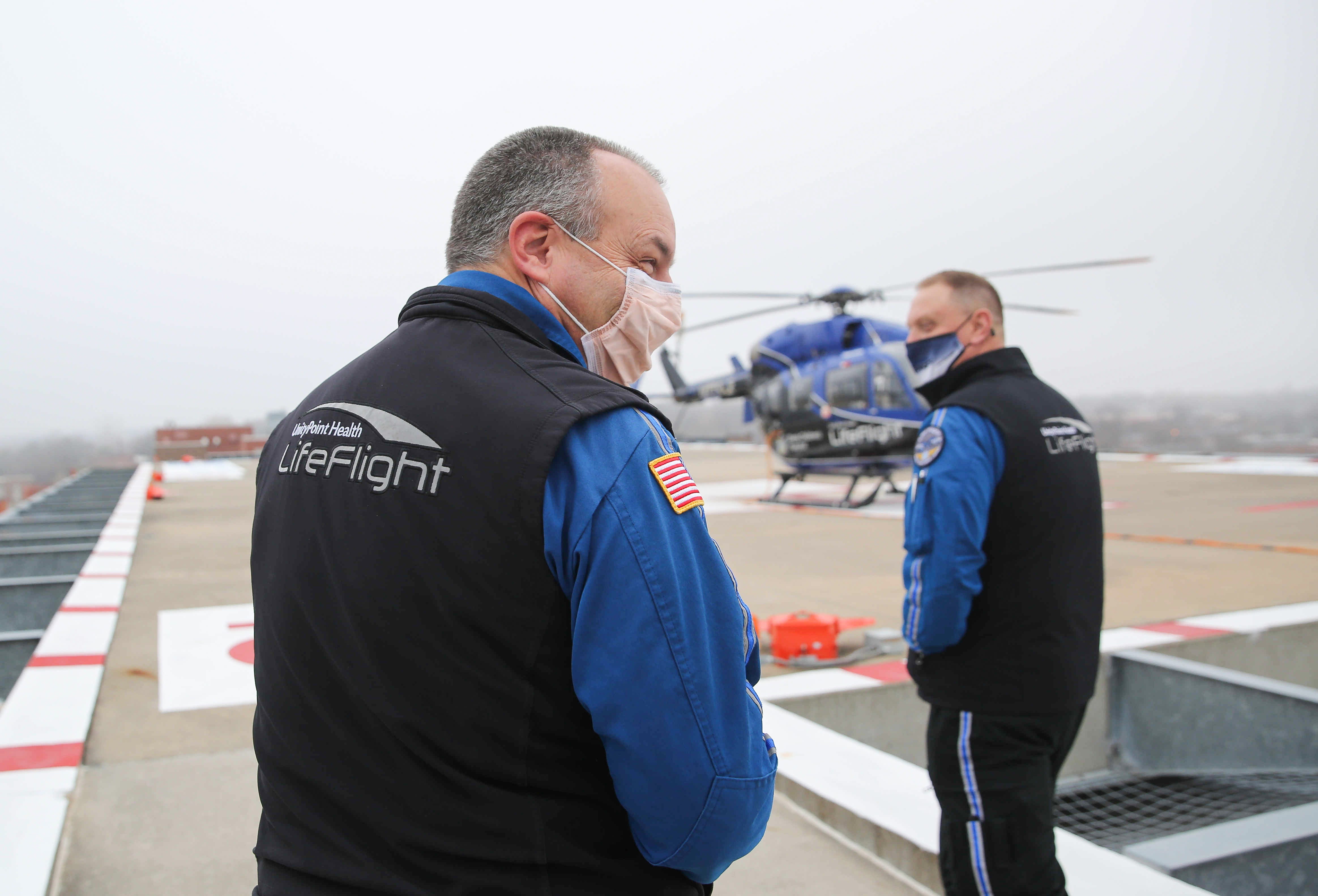 0951 DES MOINES -- UnityPoint LifeFlight nurses Brian Dotts, left, and Wes Skarda head out to observe the fog surrounding the helicopters on the 8th-floor helipad on Tuesday, Dec. 8, 2020, at Methodist Hospital in Des Moines. As of this time, the helicopters were still grounded due to heavy fog. 