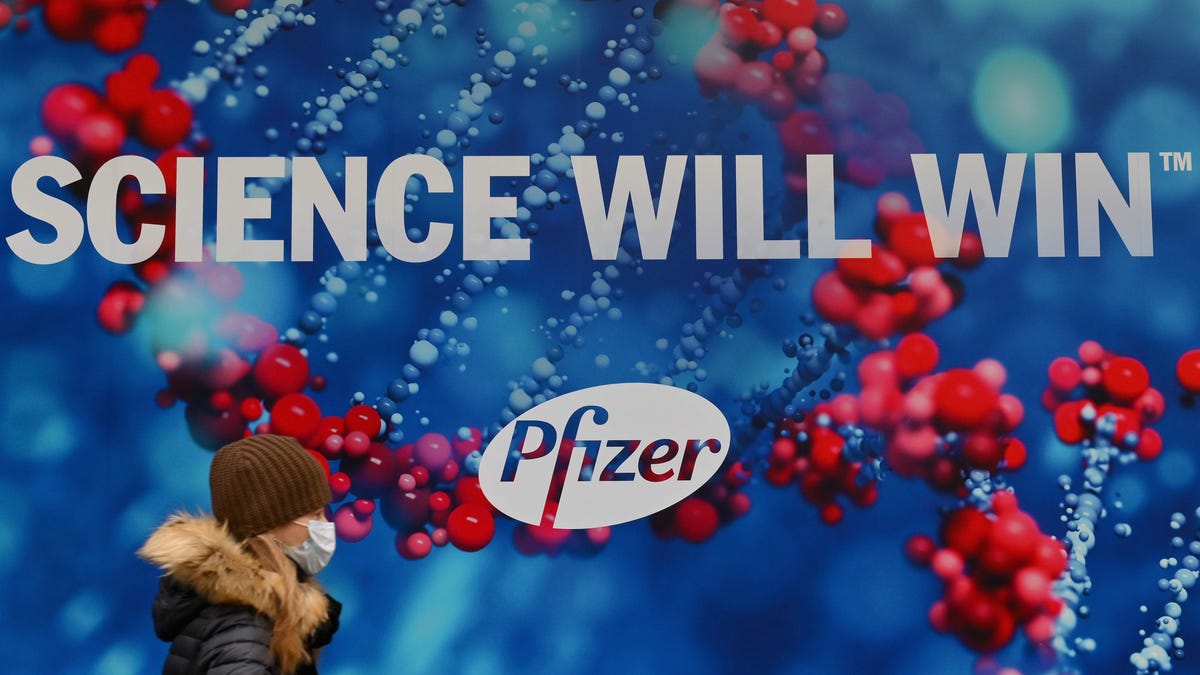 A person wearing a protective face mask walks past the Pfizer Inc. headquarters on December 9, 2020 in New York City. - Secretary of Defense Chris Miller and his top generals will be vaccinated for Covid-19 by next week after the expected approval of the Pfizer-BioNTech vaccine, Pentagon officials said on December 9, 2020.