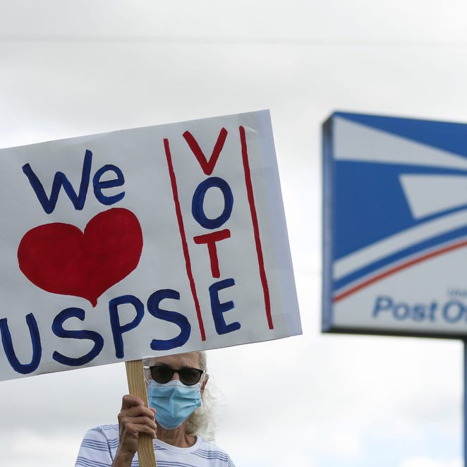 Pat Bauer marches with a homemade sign during a rally on Saturday, Aug. 22, 2020 at the Post Office in Silverton, Oregon.