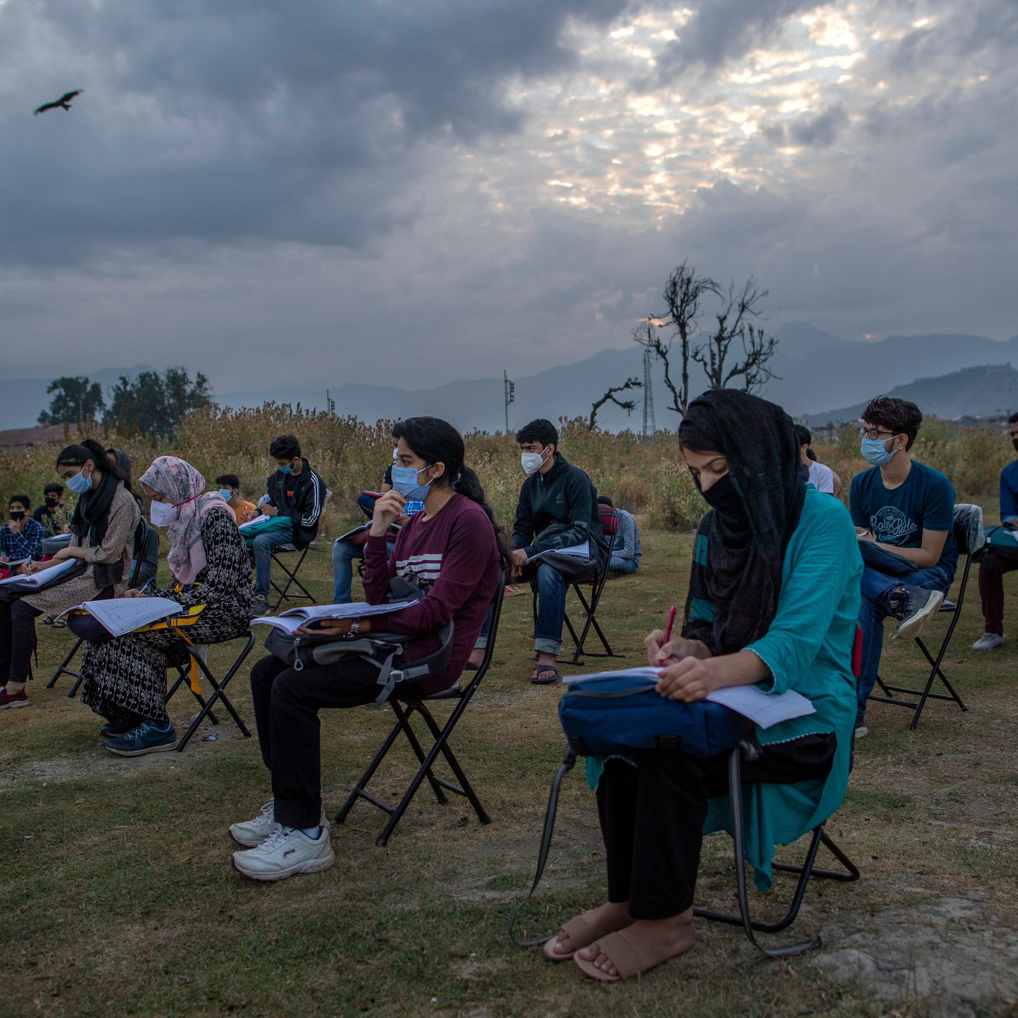 Kashmiri students attend an open-air early morning class inside Eidgah, a ground reserved for Eid prayers, in Srinagar, Indian controlled Kashmir, Friday, July 18, 2020. 