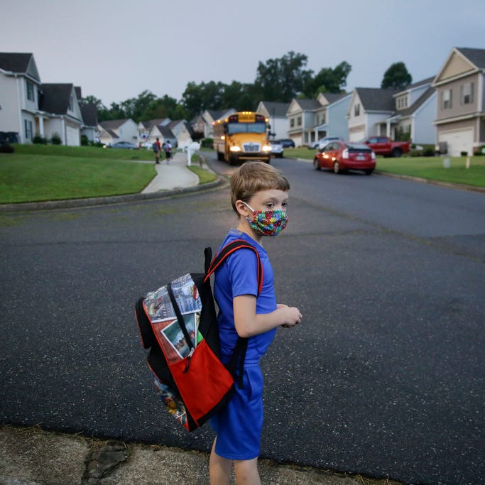 Paul Adamus, 7, waits at the bus stop for the first day of school on Monday, Aug. 3, 2020, in Dallas, Ga.