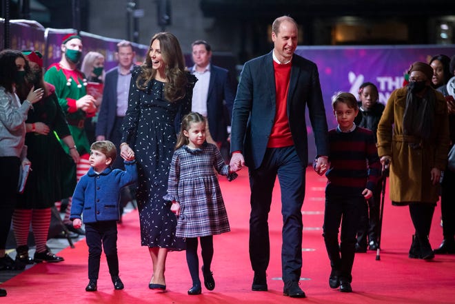 Prince William and Duchess Kate of Cambridge and their children, Prince Louis, left, Princess Charlotte and Prince George, arrive for a special pantomime performance at London