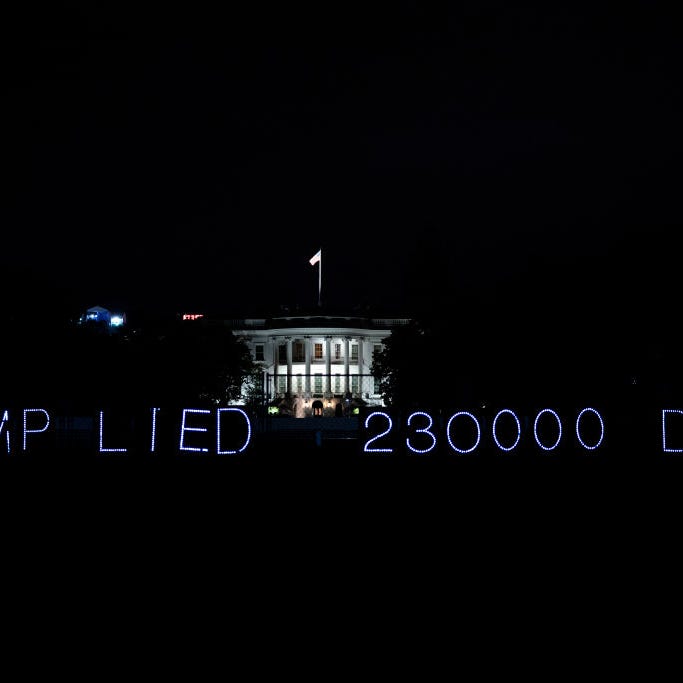 A sign reading Trump Lied, 230,000 Died is displayed outside of the White House on October 31, 2020 in Washington, DC. The United States reported close to 100,000 new cases of COVID-19 on Friday as the virus continues to surge worldwide. 
