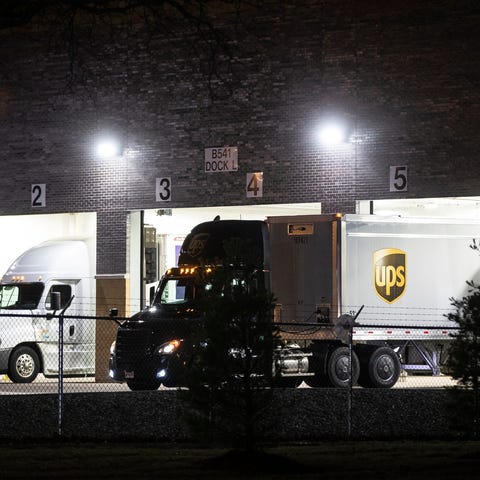 A FedEx and a UPS truck back into the loading dock