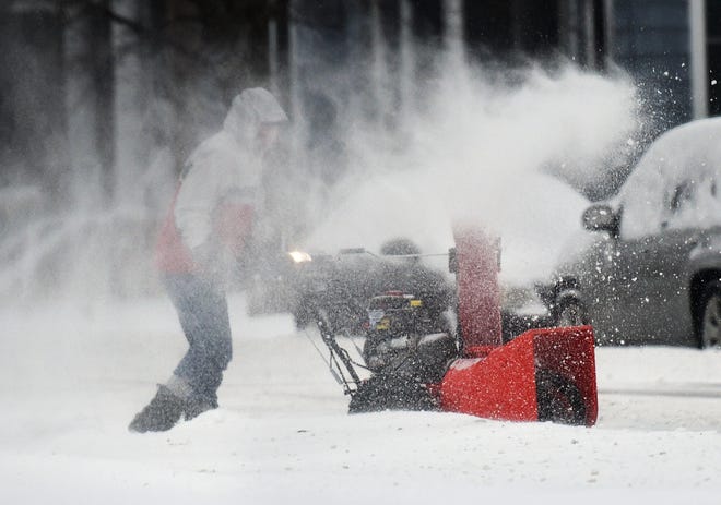 Snow whips around a Rochester man clearing his driveway with a snowblower, during a Jan. 20, 2019 storm.