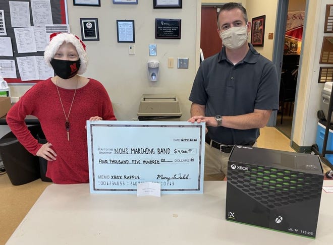 Mary Webb raffled her X-Box console to raise $4,500 that was accepted by Band Director Scott Smith. [Contributed]