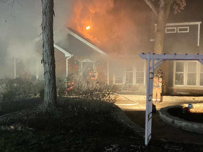 A fire spreads from an attached garage to a residence on Hazel Dell Lane in Springfield Monday evening. [Springfield Fire Department]