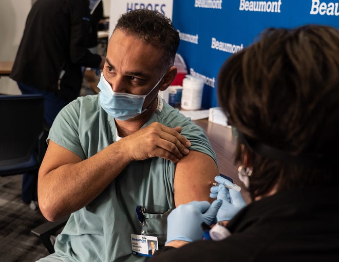 Beaumont Health Care internal medicine physician Dr. Ghadi Ghorayeb has a dose of the Pfizer-BioNTech COVID-19 vaccine administered by Carolyn Wilson as part of a "high priority group" of health care workers to receive the first doses of the vaccine at the Beaumont Service Center in Southfield on Tuesday, December 15, 2020. Beaumont Health is not mandating the vaccine for workers but strongly encouraging them to get vaccinated.