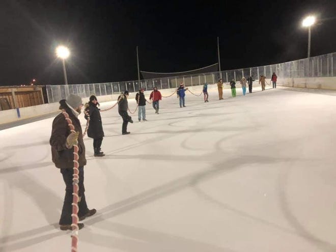 Members of the Brandon Valley Hockey Association help with putting paint on the ice at the rink at McHardy Park in Brandon on Sunday, Dec. 13, 2020.