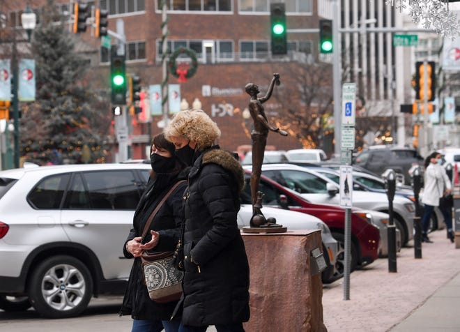 People wear masks in accordance with the city mandate while shopping downtown on Tuesday, December 15 in Sioux Falls.