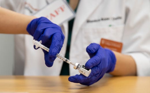 Pharmacy student Ghenica-Rose Delfin prepares the Pfizer coronavirus vaccine to be administered to hospital staff members at the University of Texas Health Austin Dell Medical School on Tuesday December 15, 2020.