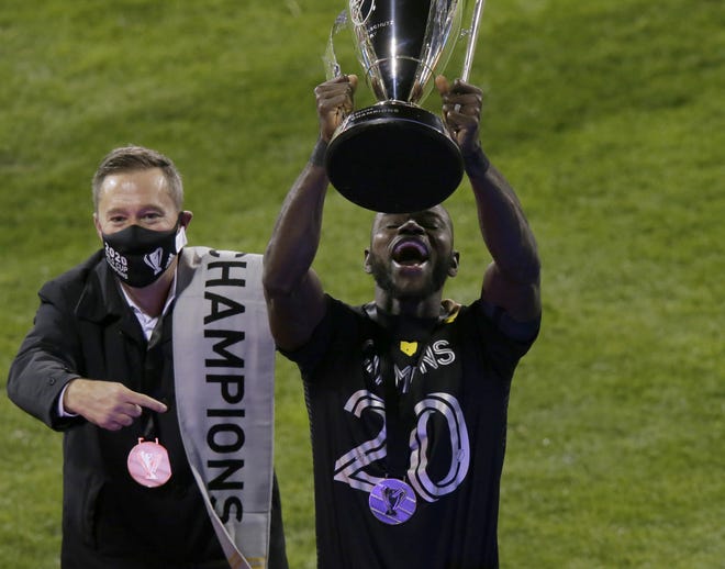 Crew defender and captain Jonathan Mensah hoists the championship trophy after Columbus beat Seattle in the MLS Cup on Saturday