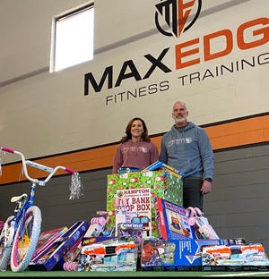 Nancy and Jay Collins with the pile of donated toys from their gym members at Hampton's MaxEdge Fitness Training. [Courtesy Photo]