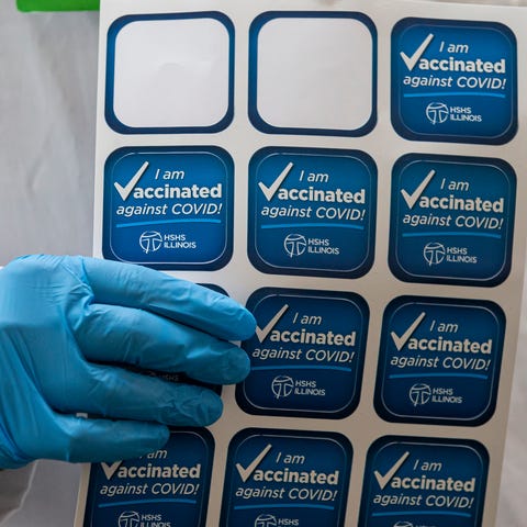 Dr. Aakash Patel holds a sheet of stickers to be g