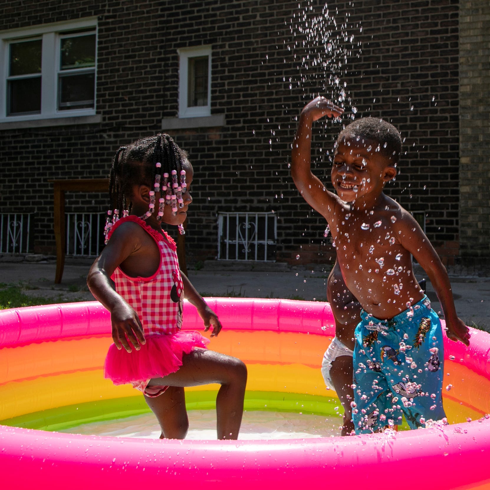Myiah Marray, 3, left, of Detroit, plays in a tiny pool with her brother Kari Marray, 4, on July 7, 2020, in an attempt to stay cool during a heat advisory.