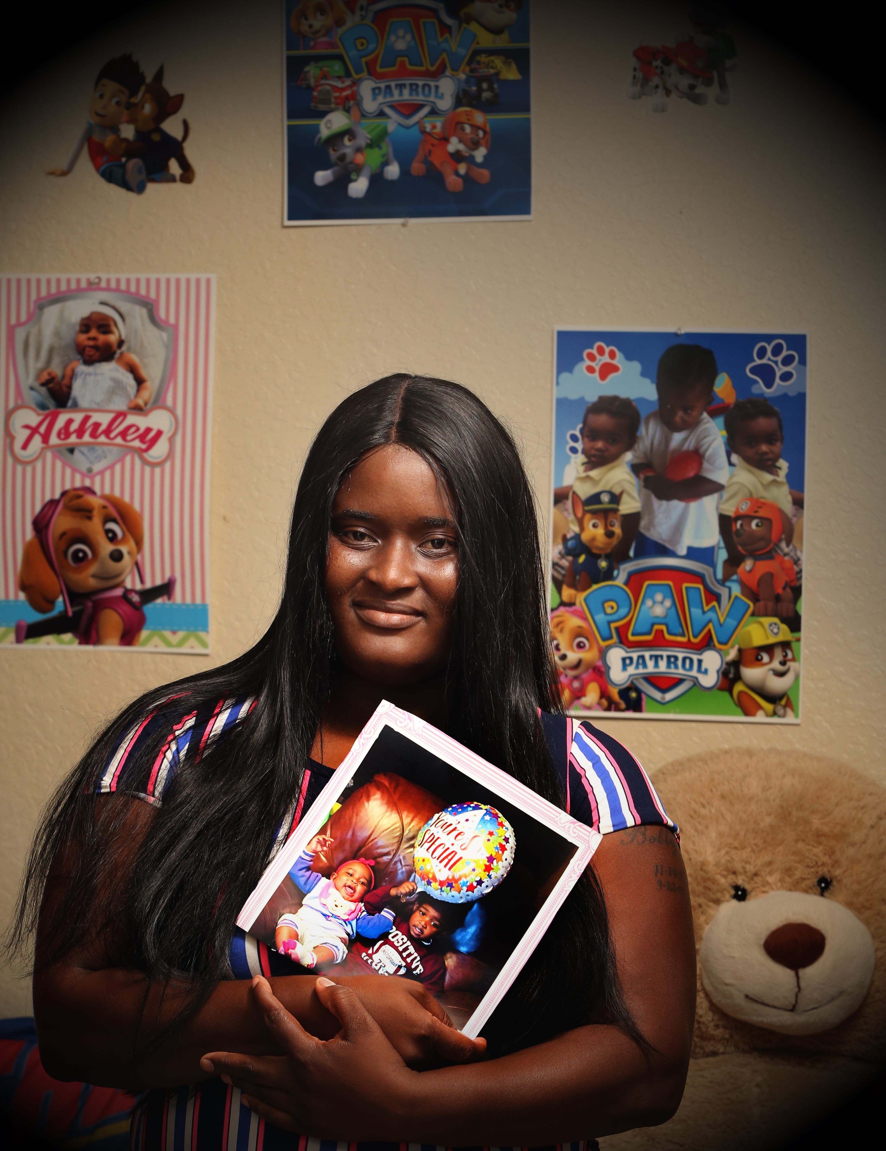 Latoya Bowles holds a photo of her children in their Riviera Beach home on Nov. 1. A judge returned her daughter and son, now 1 and 3, two weeks later.