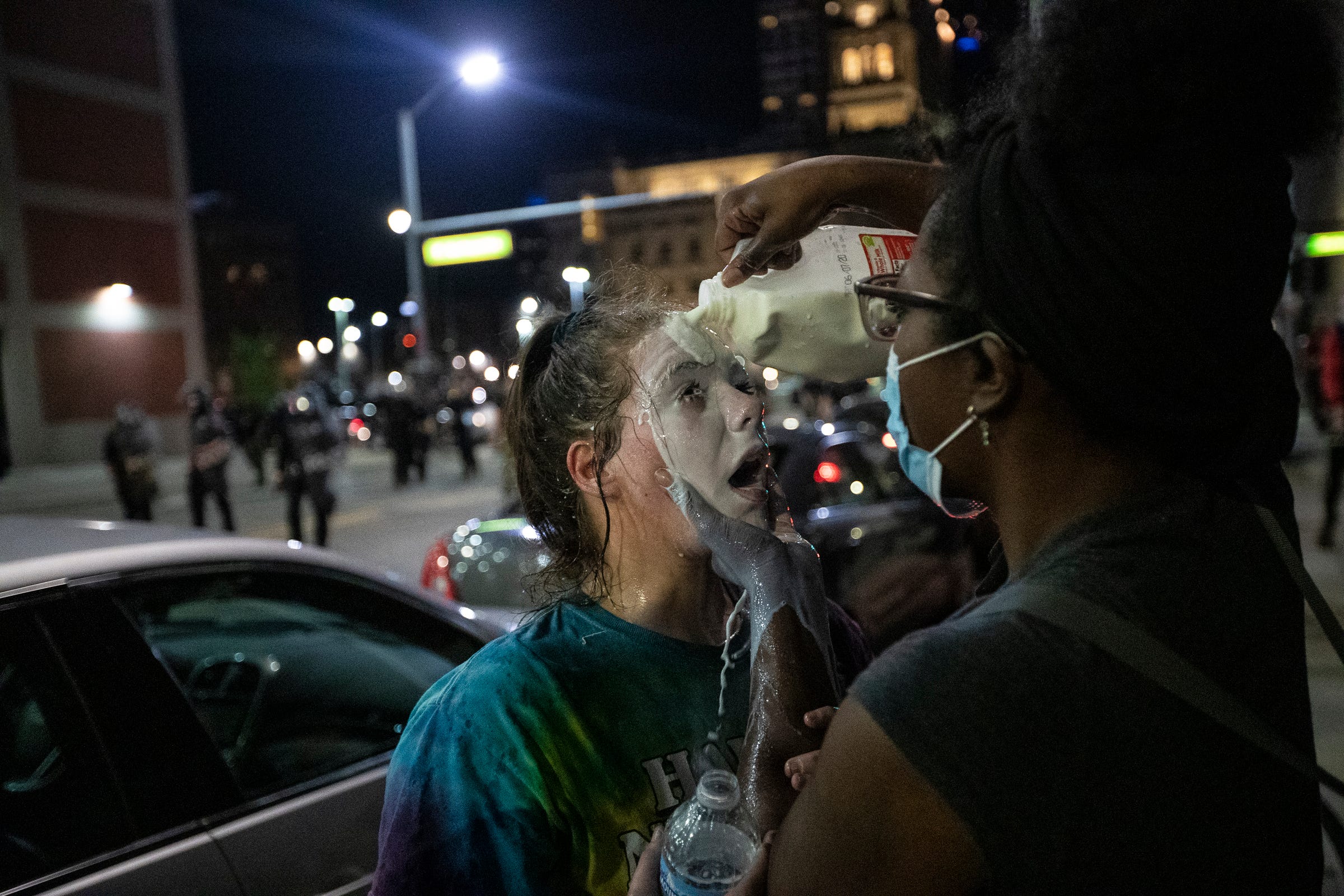 Milk is being poured on a protester's face after Detroit police officers in riot gear fired CS gas at the protesters in downtown Detroit, Friday, May 29, 2020.