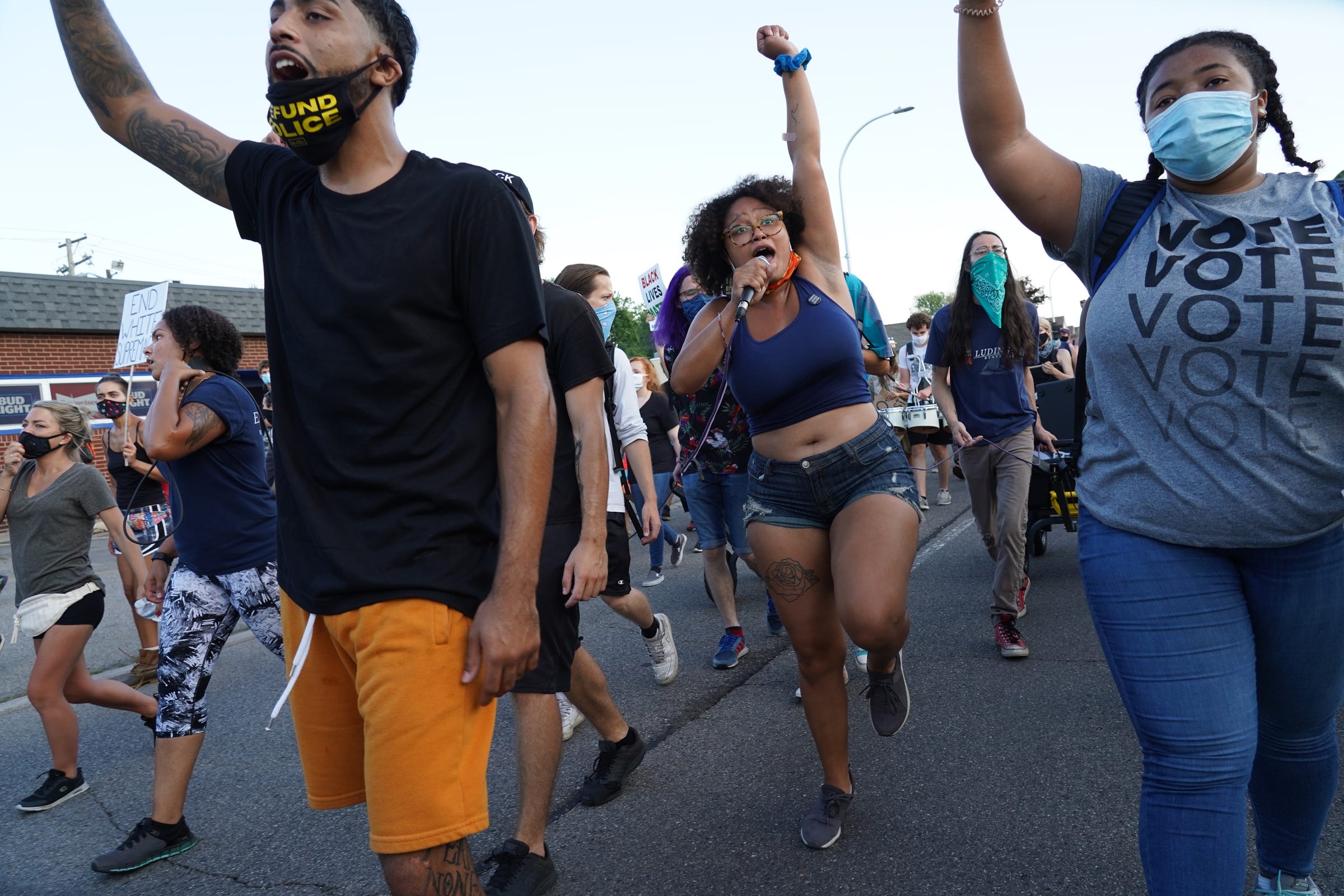 Sammie Lewis (center) of Detroit leads protesters in a chant while marching through Harper Woods for Priscilla Slater on Friday, July 24, 2020. Slater was found unresponsive in a Harper Woods Police Department holding cell in June 2020.