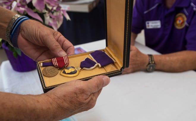 A Purple Heart medal is inspected Tuesday, December 15, 2020, during a meeting by veterans and purple heart recipients held at the Brotherhood of Heroes Military Museum and Resource Center in Cape Coral. 