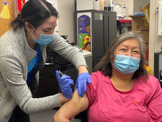 Bryar Flansburg-Gilham, a Fort Belknap, Montana, public health nurse, vaccinates Belva Bell, a tribal health nurse.