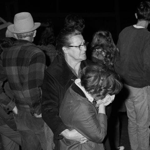 A woman is comforted at the site of the Finley-Hur