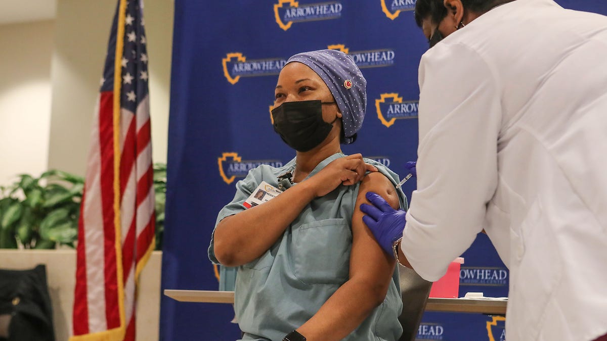 ICU nurse Sonya Harrell receives the first dose of Pfizer BioNTech vaccine administered by Marcia Willams at Arrowhead Regional Medical Center in Colton, Ca., December 16, 2020.