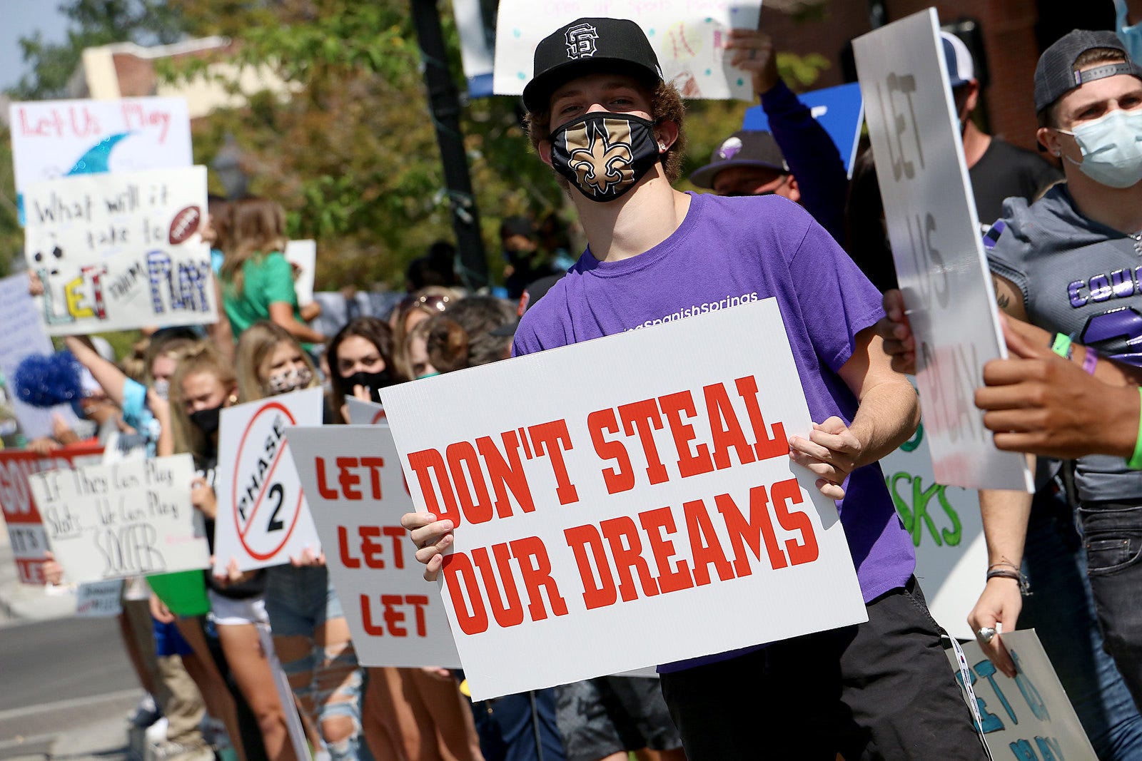 Spanish Springs football player Logan Martin holds up a sign at a rally in front of the Nevada State Capital Building to encourage Governor Sisolak to allow high school sports to be played on Sept. 19, 2020.