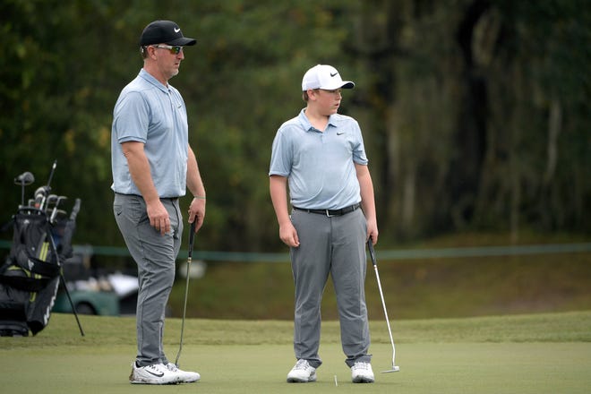 David Duval (left) and his son Brady read a putt during the 2018 PNC Father-Son Challenge in Orlando.