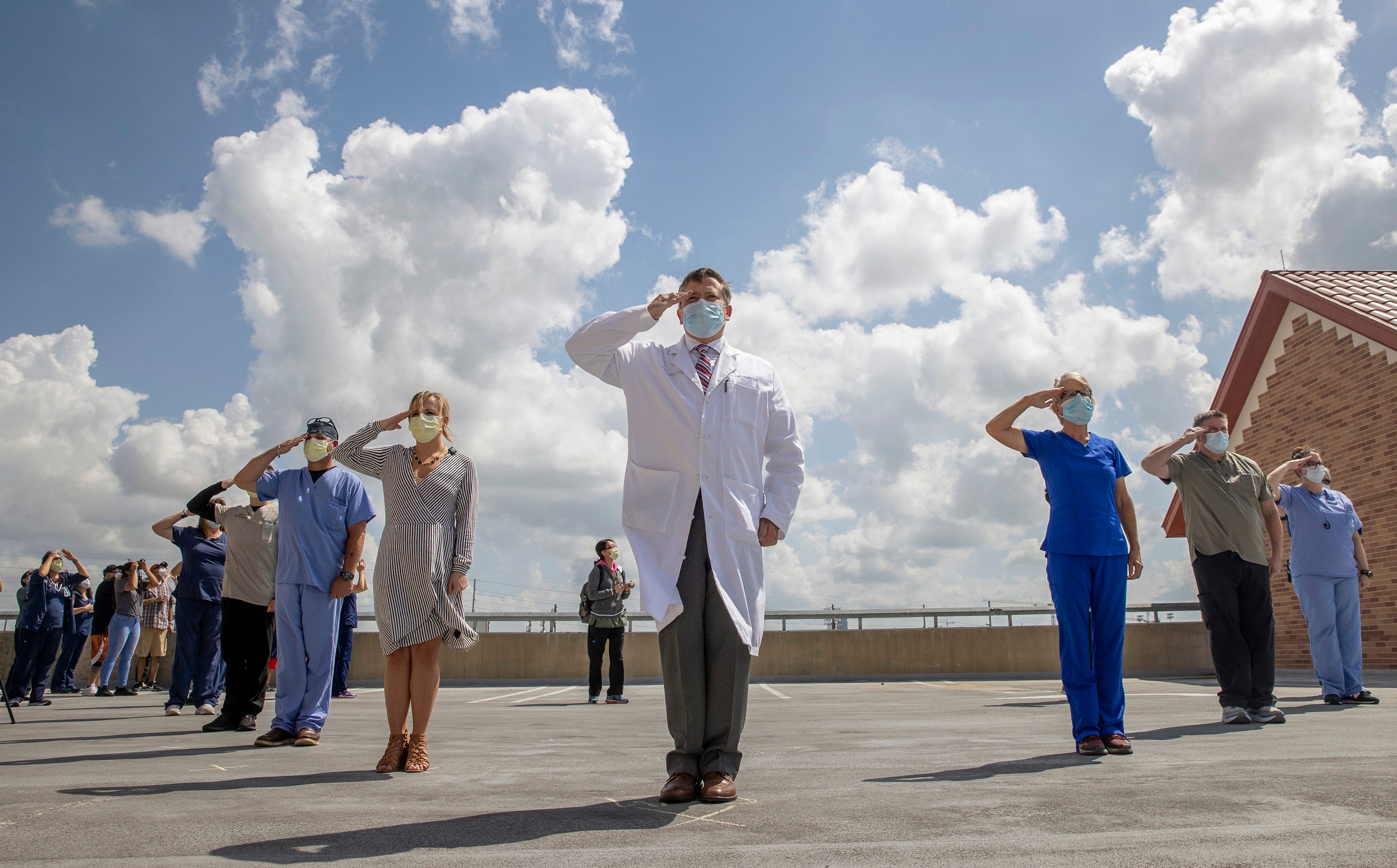 Dr. Andrew Moore, middle, Chief Medical Officer at St. David’s Medical Center, along with other doctors, nurses, technicians and administrators who served in the military, salute as the U.S. Air Force Thunderbirds fly over St. David’s Medical Center to honor front-line workers and health care professionals serving in the coronavirus pandemic on Wednesday May 13, 2020.   The air demonstration squad performed a 35-minute flyover in the Austin metropolitan area.
