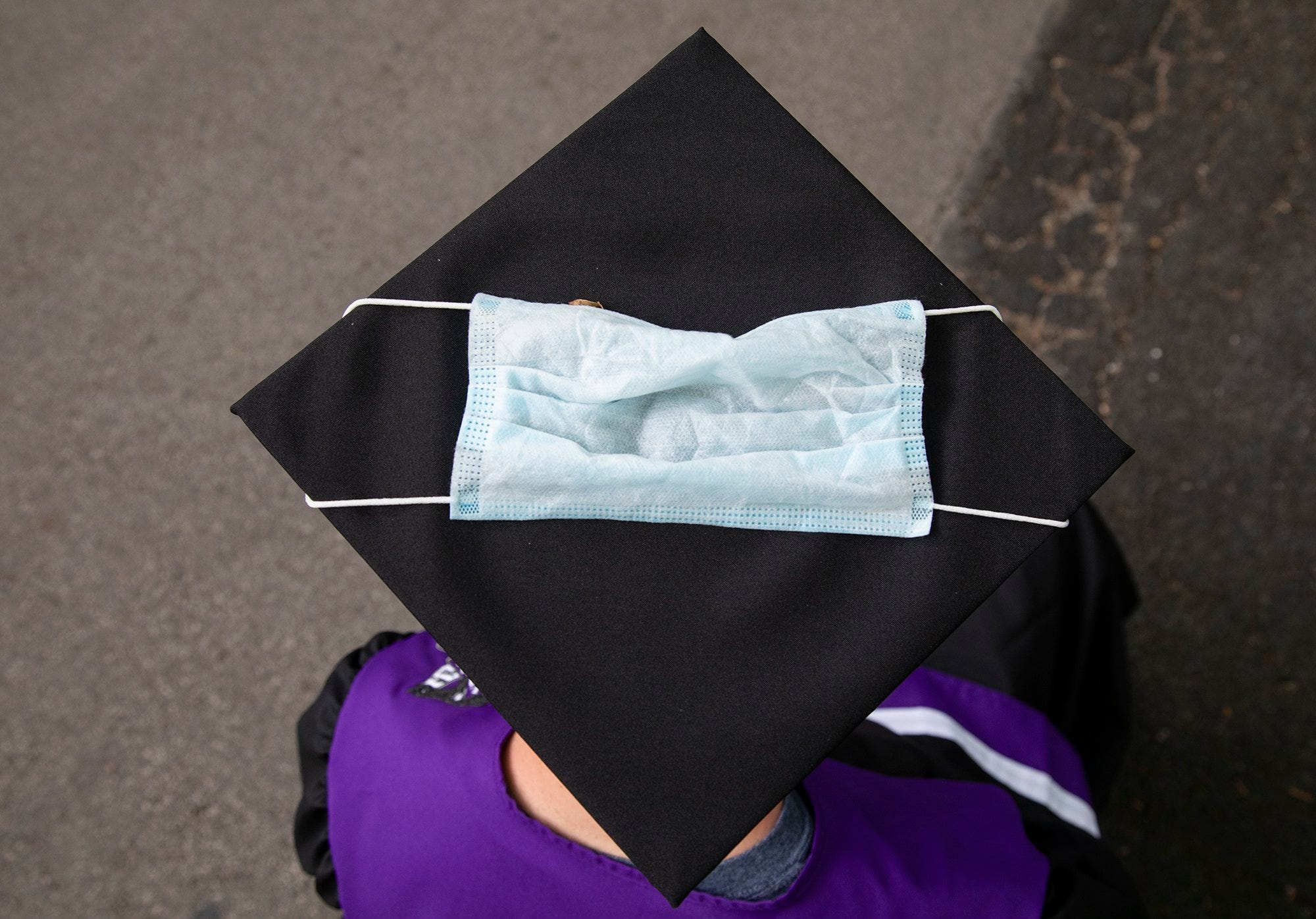 Liberal Arts and Science Academy Champ Turner sports a mask on his graduation cap while participating in a block graduation ceremony on May 29, 2020, in Hyde Park. All of the seniors live blocks from one another and attended McCallum High School or Liberal Arts and Science Academy.