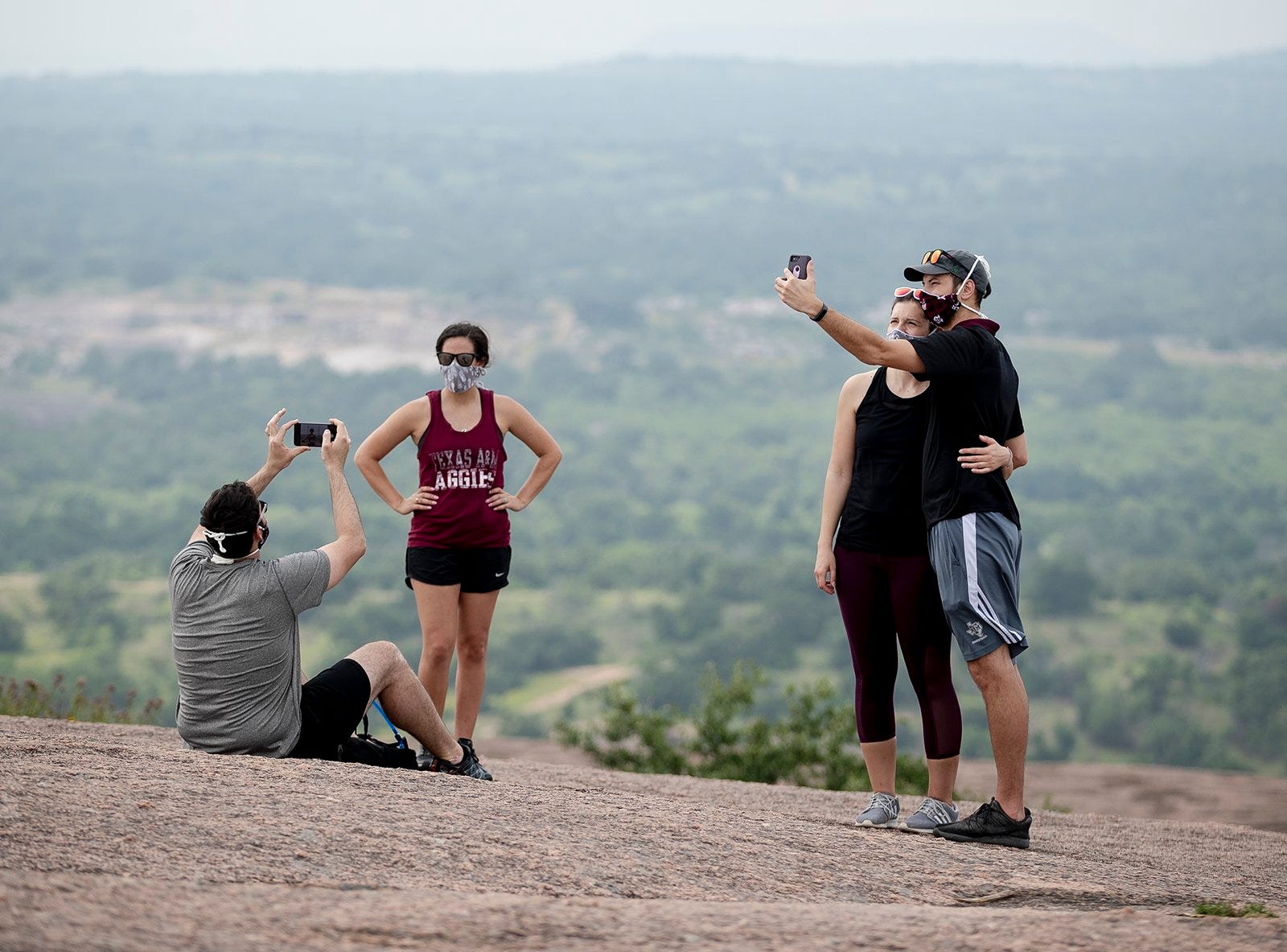 Quentin Holtz, left, takes a photo of his wife, Jessica, while Dakota Thompson and his girlfriend, Margaret Butzen, take a selfie at Enchanted Rock State Park on Tuesday, April 21, 2020, near Fredericksburg, Texas.