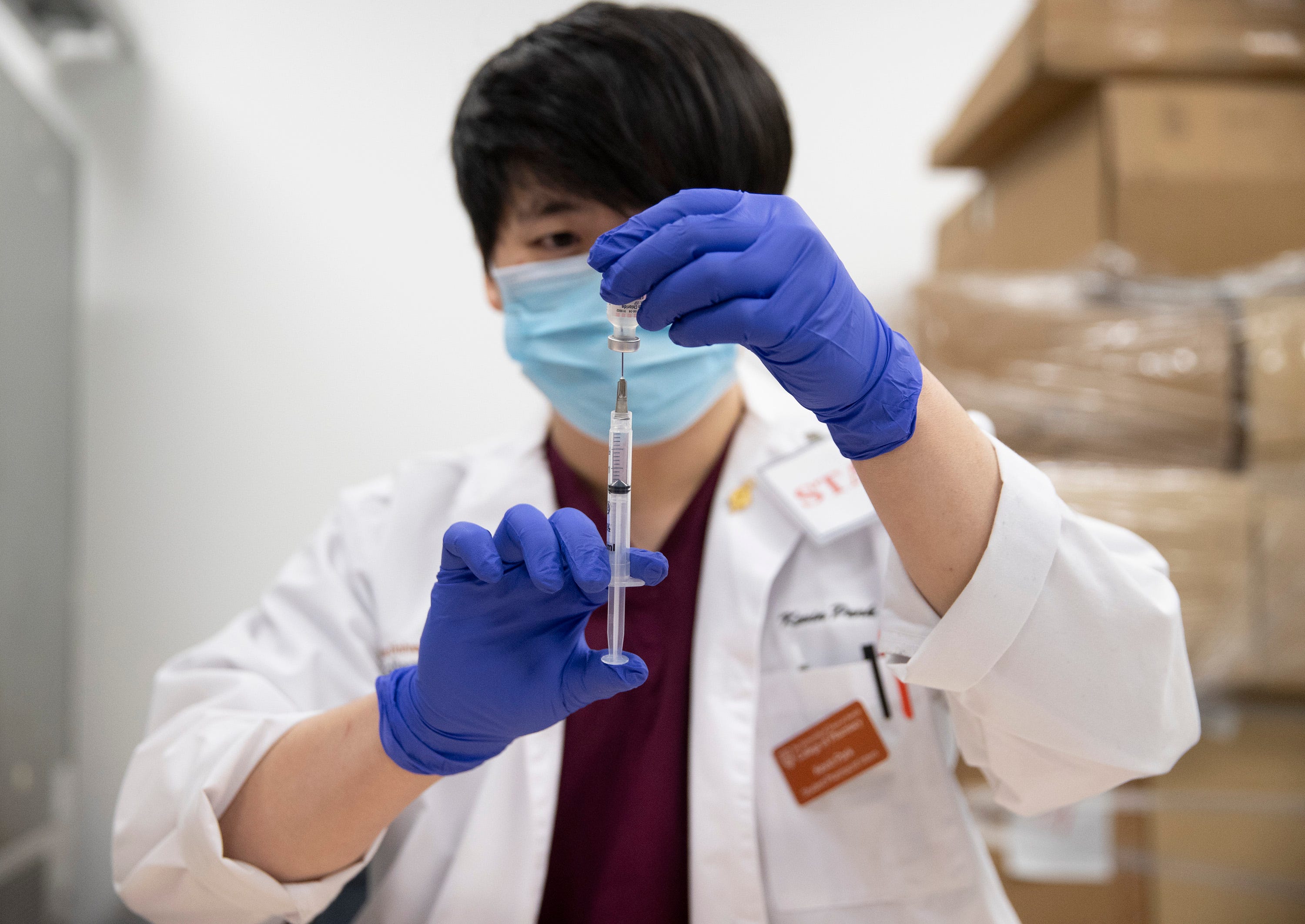 Pharmacy student Kevin Park prepares the Pfizer coronavirus vaccine to be administered to hospital staff members at the University of Texas Health Austin Dell Medical School on Tuesday December 15, 2020.
