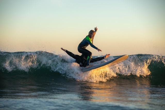 Chris Antao guía a una atleta de surf Gnome mientras atrapa una ola.
