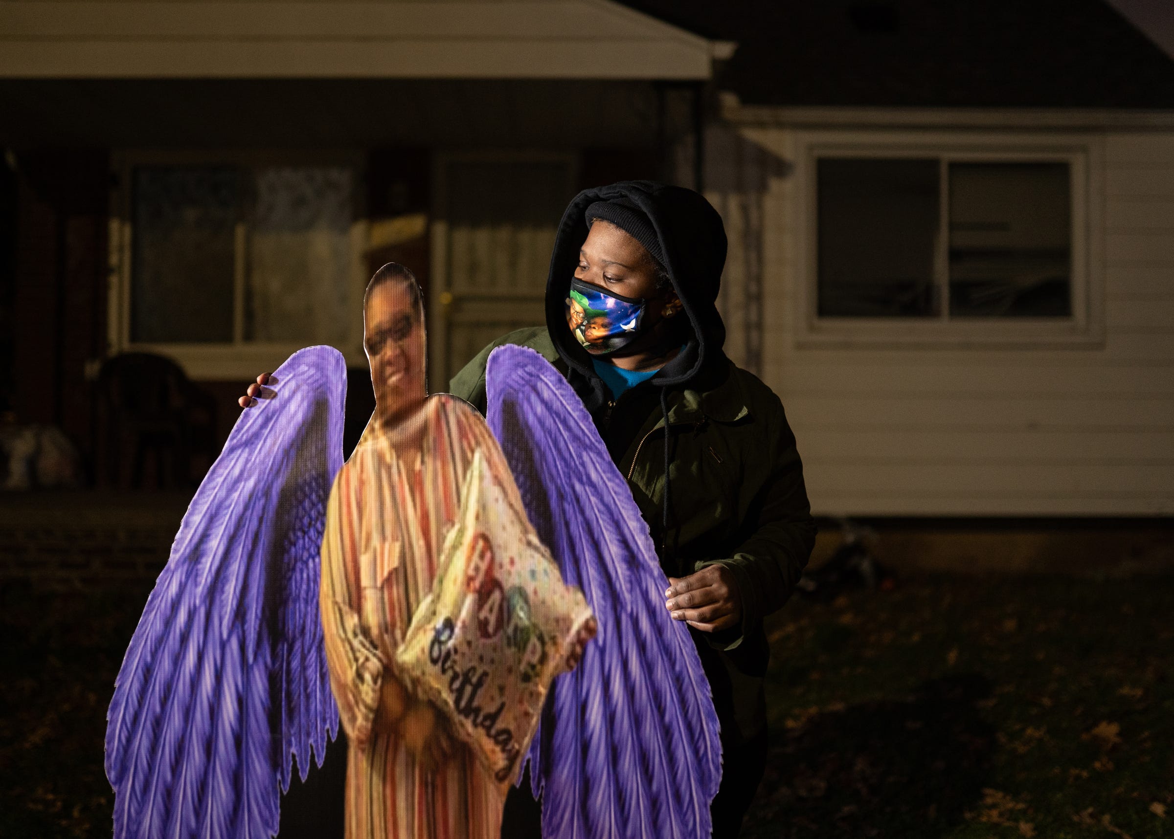 Juliette Gilbert, 33, of Detroit stands with a cutout of her mother, the late Monique Baldridge, 52, who died due to COVID-19. Her mother fell ill in March 2020 and was hospitalized for about two weeks. Gilbert said her mother lived with her and her three kids. 