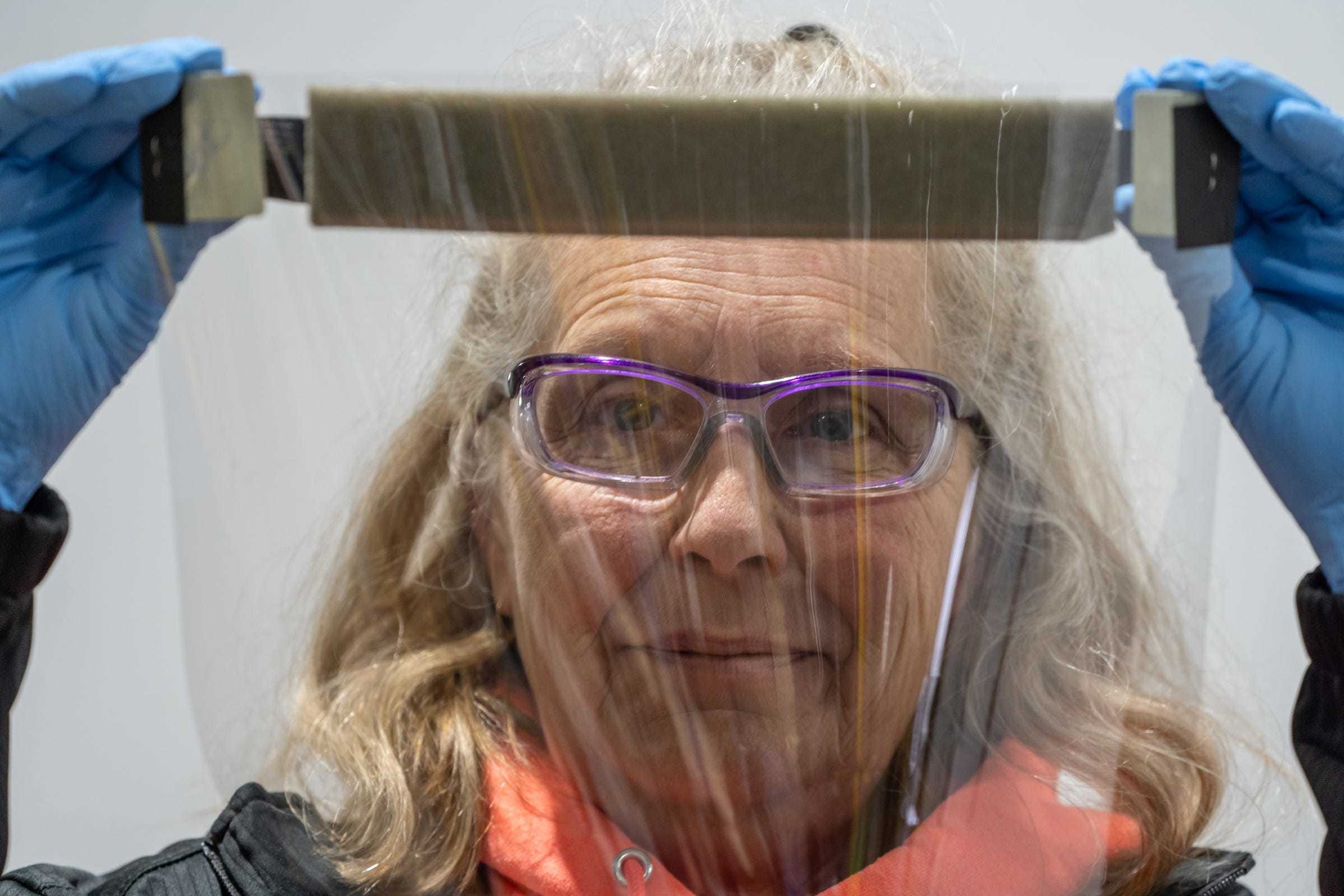 Pat Tucker shows one of the protective face shields she assembled at Troy Manufacturing Design, a Ford subsidiary in Plymouth, on Friday, March 27, 2020. Ford, in cooperation with the UAW, will assemble more than 100,000 critically needed plastic face shields per week to help medical professionals, factory workers and store clerks.