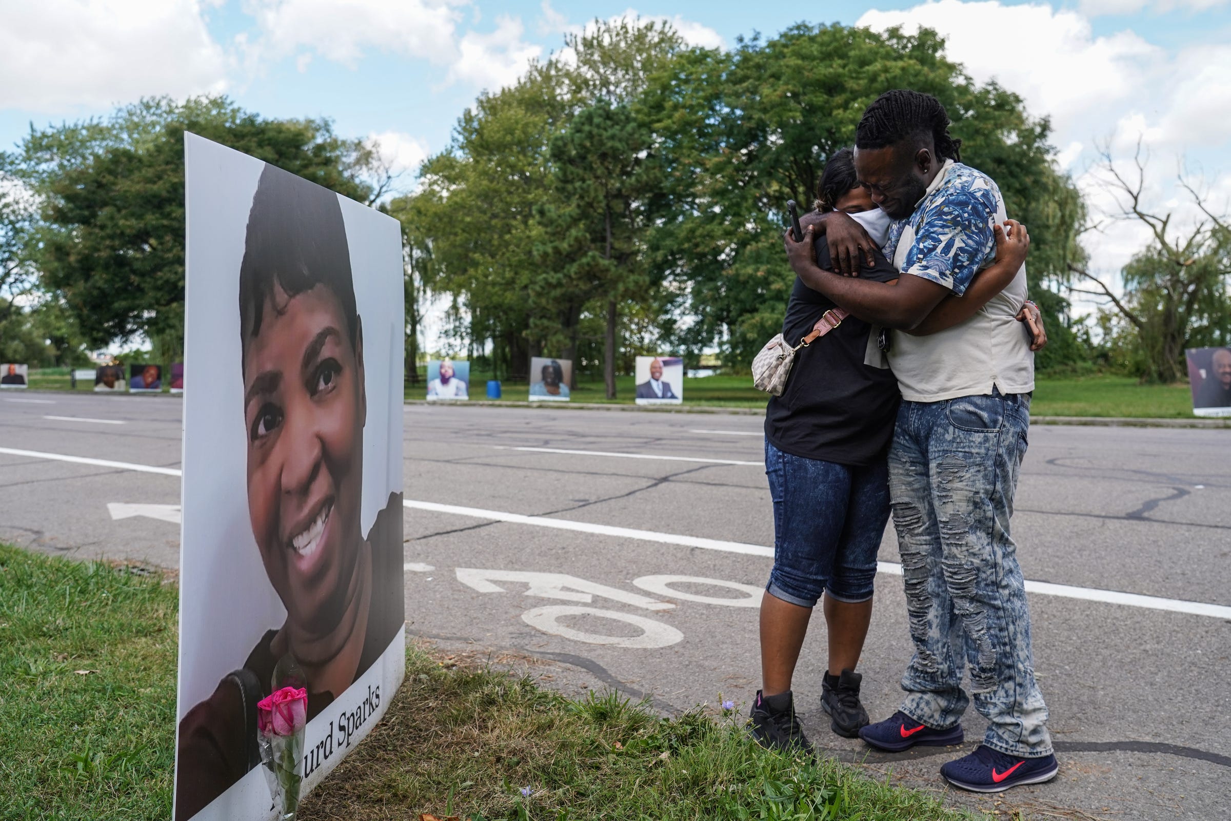 Delano Sparks of Detroit is comforted by his sister Jamie Cook of Detroit as they get out of their car at a photo of their mother, Asturd Sparks, on display as part of photos of Detroit residents and people with connections to Detroit who died during the pandemic during the Memorial Drive on Belle Isle in Detroit on Monday, August 31, 2020.
"Driving through it was a lot to sink in because you realize that you're not the only person that's hurt. Looking at all of these pictures and stuff make you realize that it's a lot of people that were truly affected by this. This for me just means that we all just need to band together, vote and just make everybody as happy as you can while you're here on this earth," Sparks said. "We can be gone in five minutes. I know for a fact. I talked to my mom. It was the first time she ever told me she was scared when she was in the hospital." He wasn't let into the hospital in April to see his mother. "This is hard. This is the hardest thing I've ever been through in my life. It still hits me like it was yesterday and it's been months," he added.