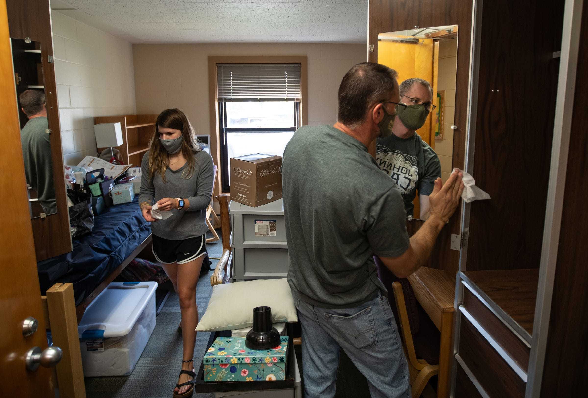 Lake Superior State University junior Rebecca Weipert of Leroy and her father William Weipert disinfect her room in Osborn Hall during a move-in day for students at Lake Superior State University in Sault Ste. Marie in Michigan's Upper Peninsula on Wednesday, August 5, 2020. "It's stressful to send them into something you don't know if it's truly safe or not. We know it's not 100 percent safe," Weipert said about his daughter returning to campus. "We're excited for her to get to her halfway point but we're equally as nervous about her having to do it this way." 
This year Weipert brought extra masks and supplies for her own room. She has one of her five classes online due to the class size. "A lot of students are saying they think that it's going to go back online because people aren't going to follow the rules. I really hope it doesn't happen. It's hard to learn online especially with certain classes. That's why we're here is to learn and get the full potential of every class to get that kind of education," she said.