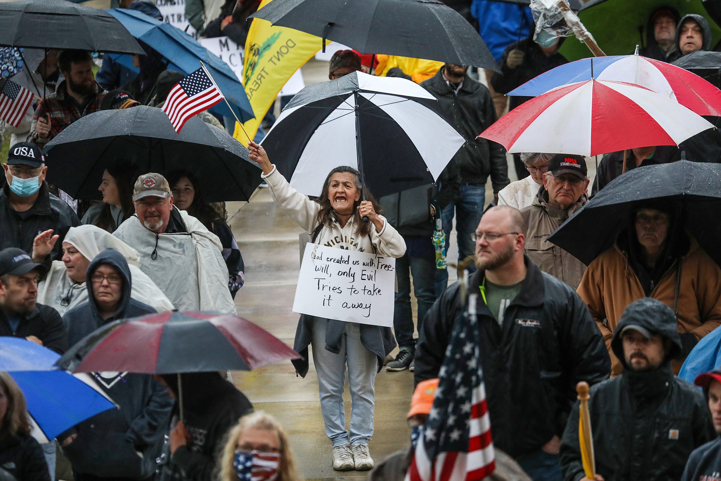 Protestors listen to a speaker on the Capitol steps during a protest rally against Gov. Gretchen Whitmer's order to stay home during the COVID-19 pandemic in Lansing, Mich. on Thursday, May 14, 2020. 
