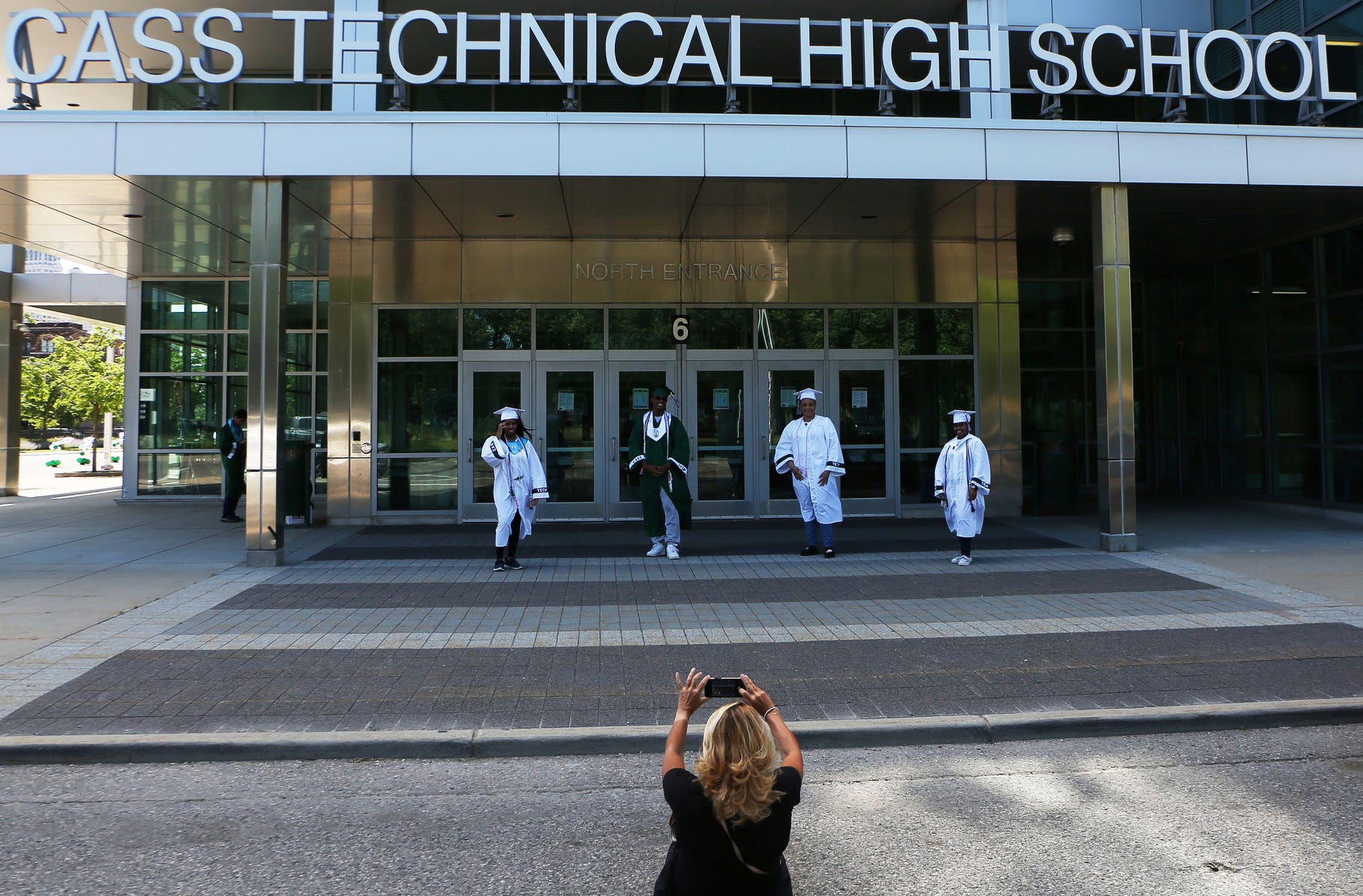 Cass Technical High School English teacher Lauralyn Taylor photographs seniors during the Cass Tech seniors' graduation clearance on Friday, June 12, 2020. With social distancing still in place, a graduation clearance pull up was the best option.