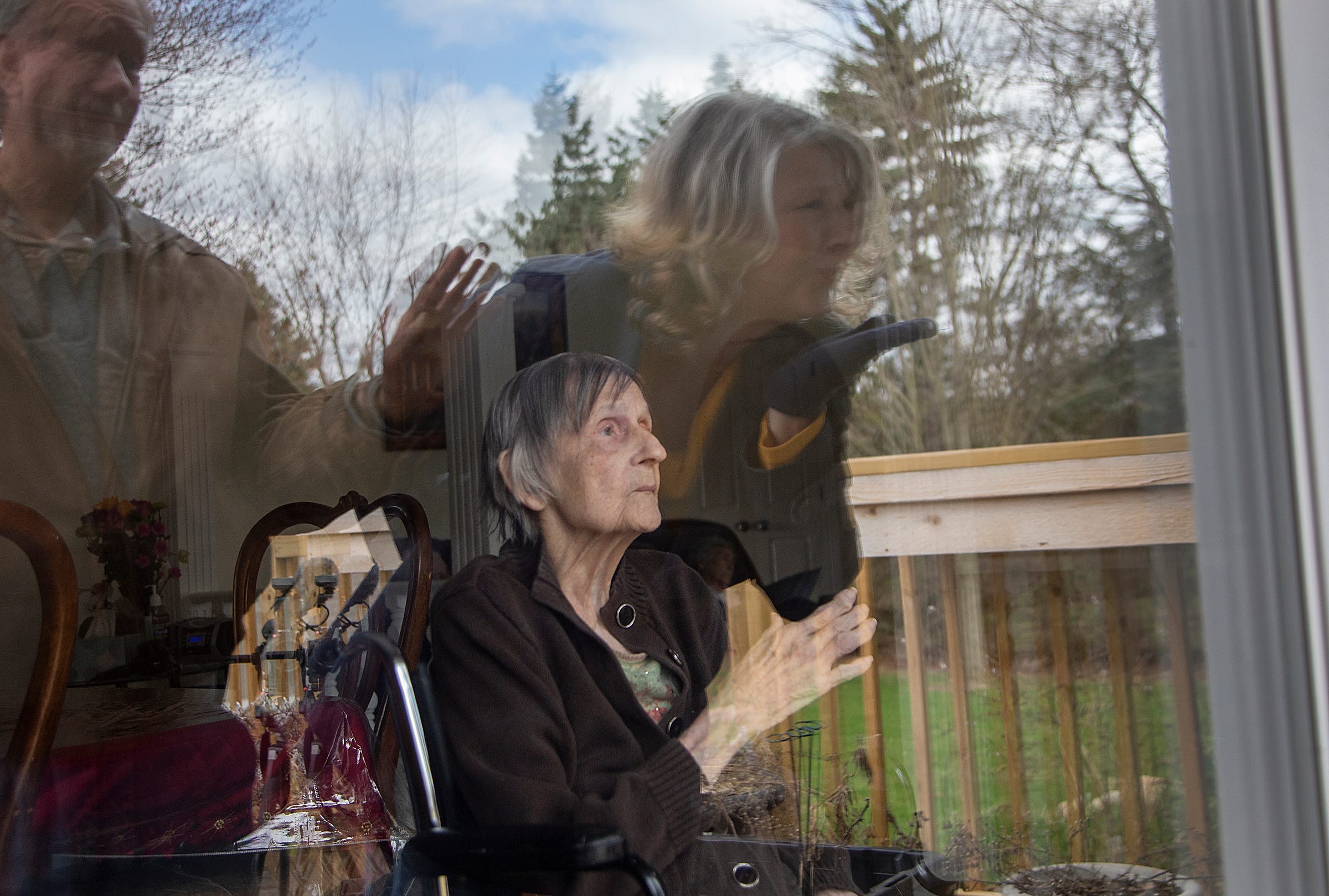 Sister of the late Eric Dubke, Michelle Voineag, blows her mother Mary Dubke a kiss through a window on Friday, April, 10, 2020 at her group home in Northville. Their mother suffers from late-stage Alzheimers and Voineag agonized over whether to tell her that her son Eric died from COVID-19.