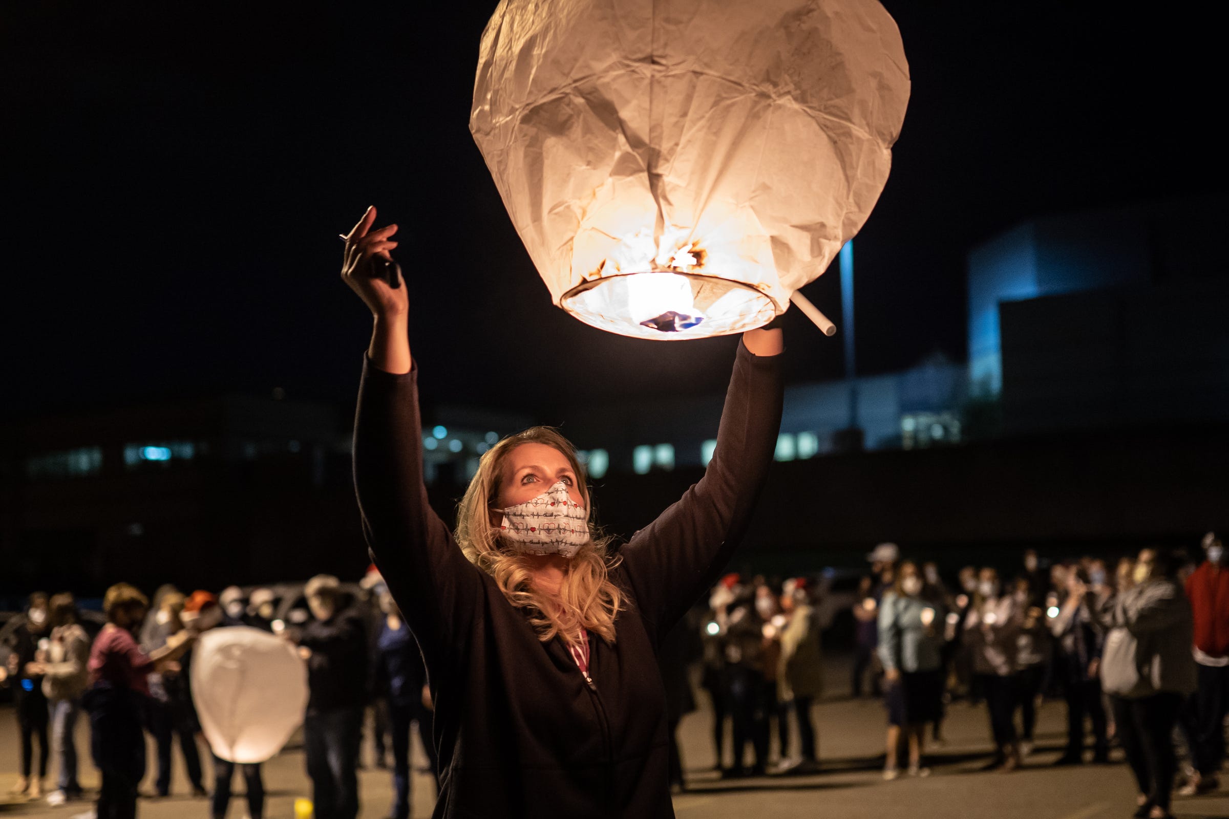 McLaren Flint nurse Vikki Inman releases a paper lantern during a candlelight memorial and prayer on Monday, November 9, 2020 at St Paul Lutheran Church in Flint for the late Santa Staples, a fellow nurse at the hospital who passed away from COVID-19.