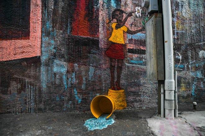 “New Normal,” a mural designed by Hattiesburg artist Andrea Kostyal is located at 402 Main St. in downtown Hattiesburg, Miss., pictured here Friday, Dec. 18, 2020. The mural features an installation of an overturned water bucket as part of the piece.