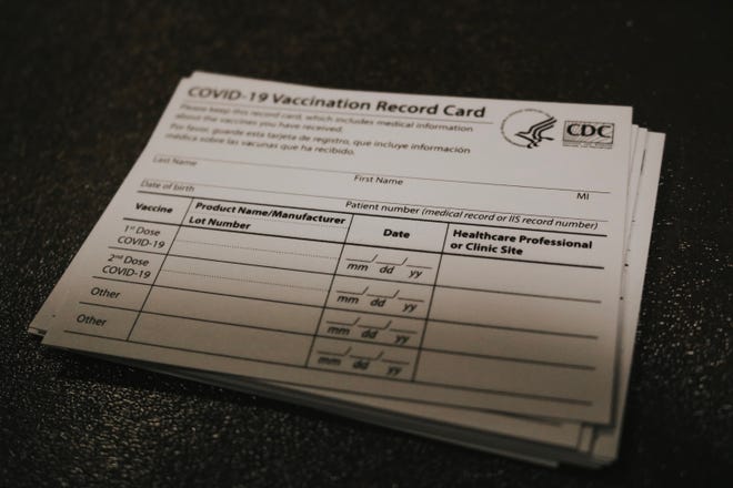 A COVID-19 vaccination record card at Ball Memorial Hospital's vaccine clinic.