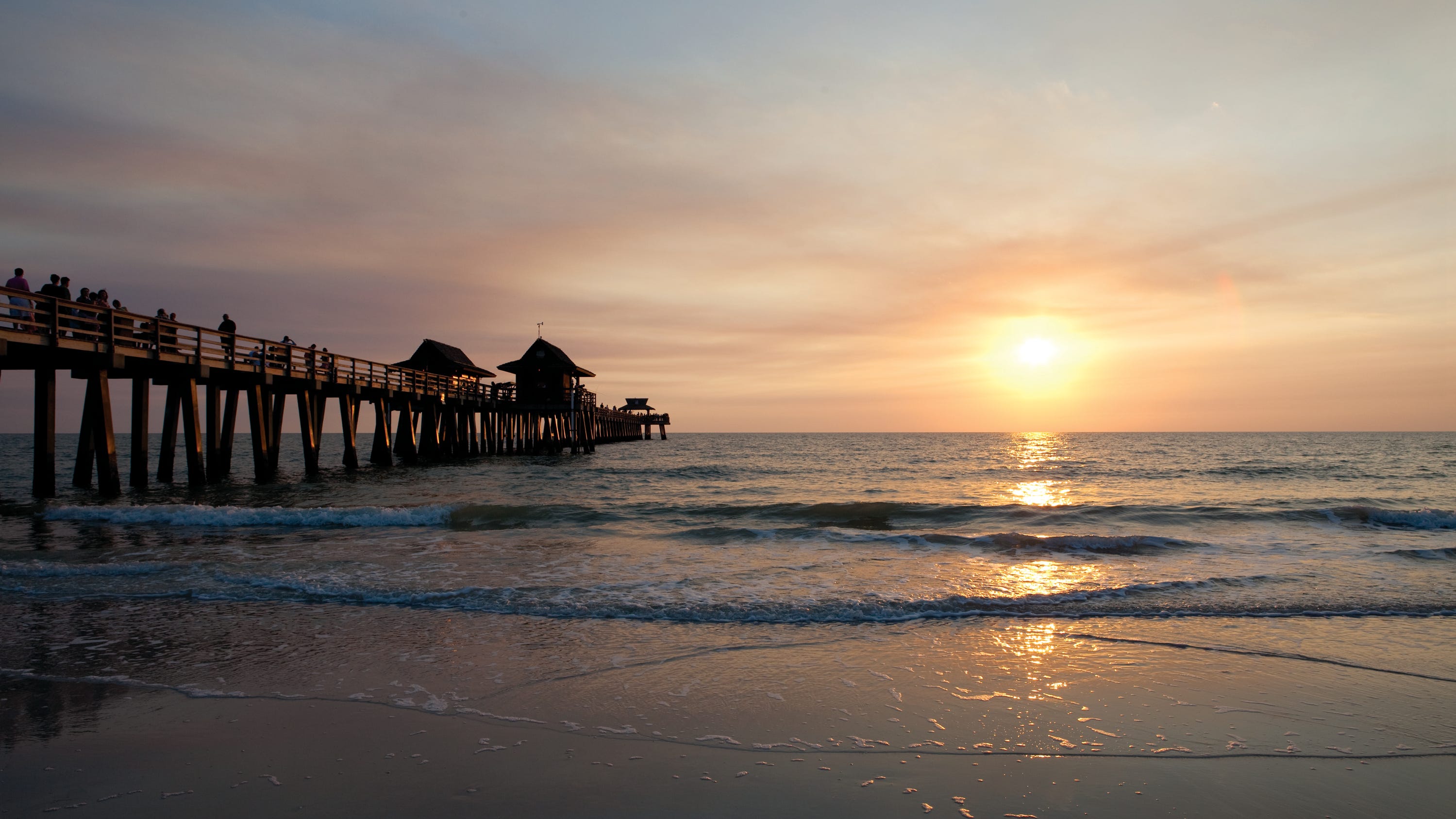 The sun sets over the Gulf of Mexico and Naples Pier, a free attraction for fishing, strolling or just relaxing.